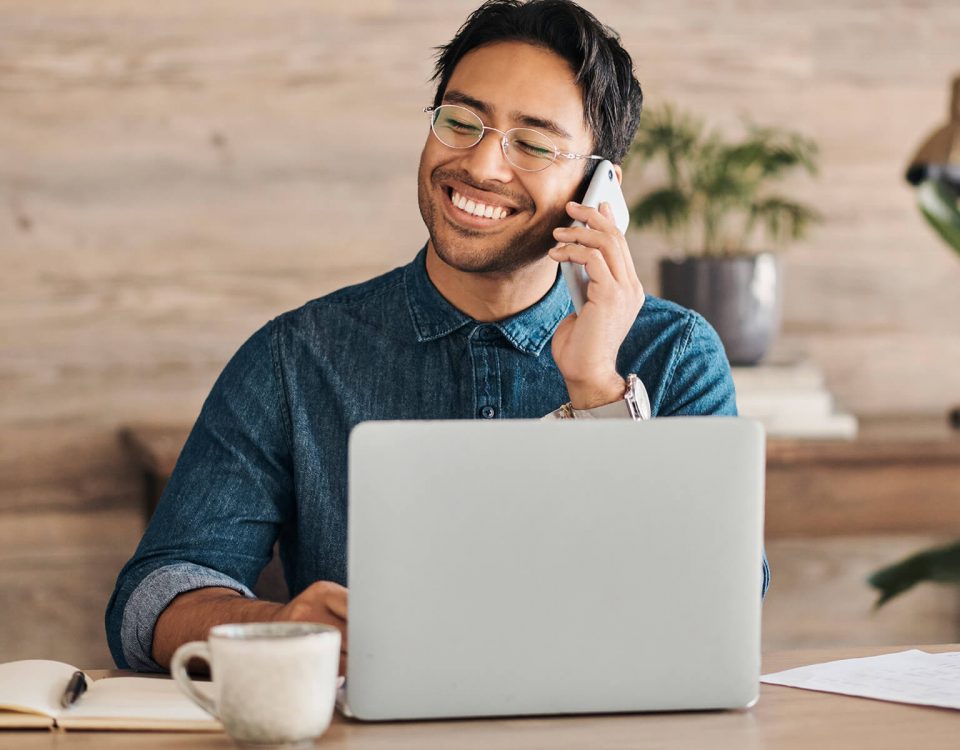 personne répondant au téléphone devant son ordinateur portable